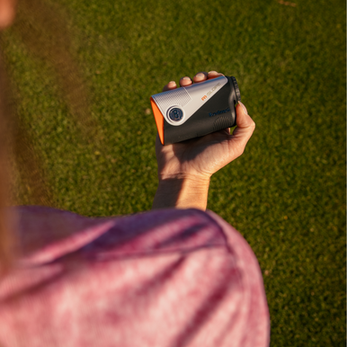 Golfer holding A1-Slope Laser Rangefinder with BITE Magnetic skin.